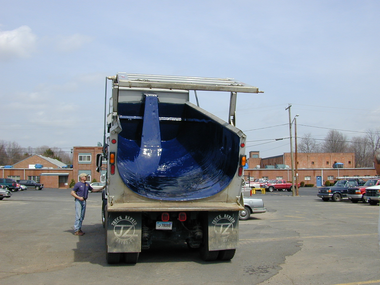 Municipal truck body lined with a seamless blue polyurea coating