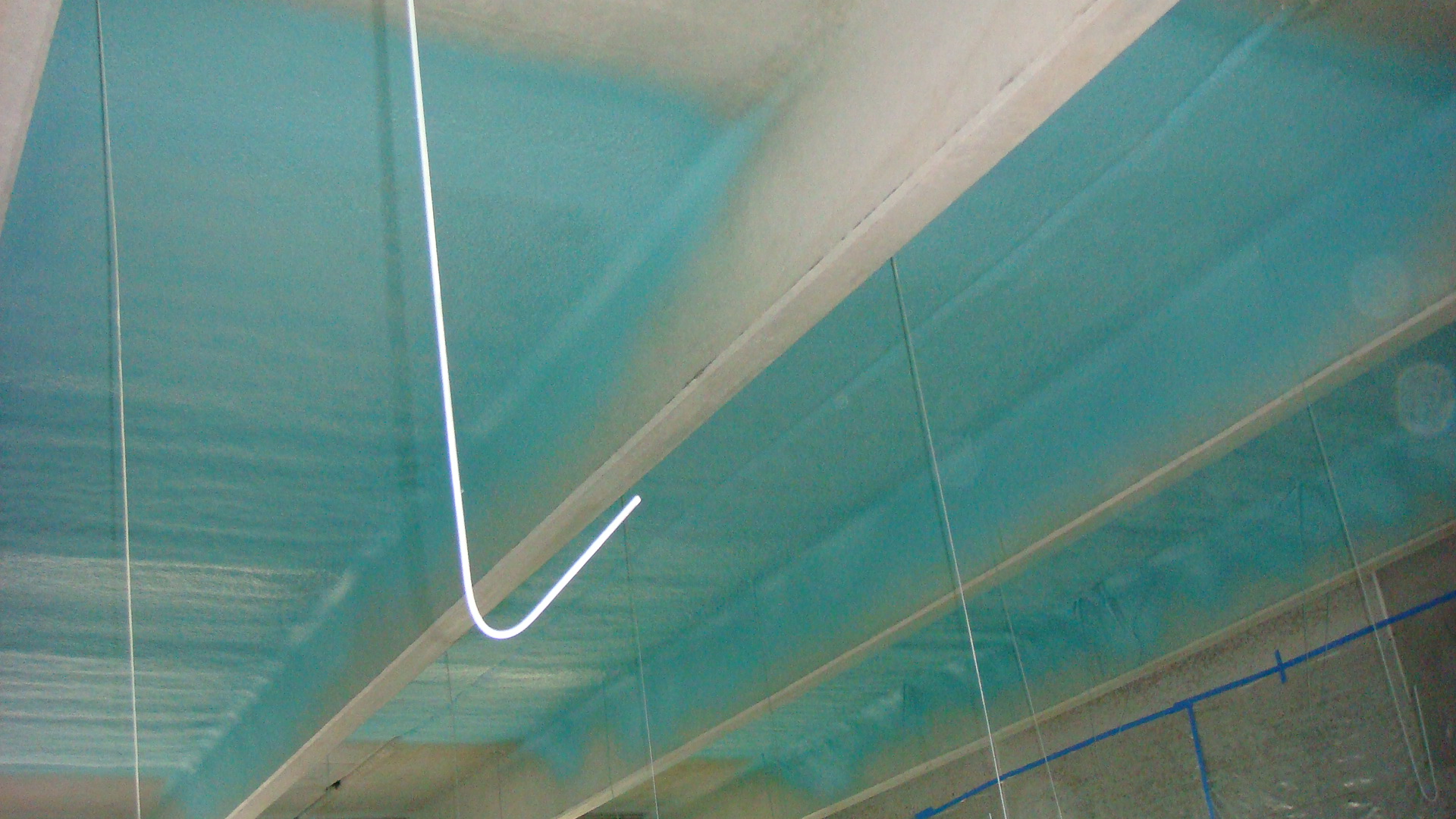 Industrial polyurea coating application — contractor applying protective coating to large surface