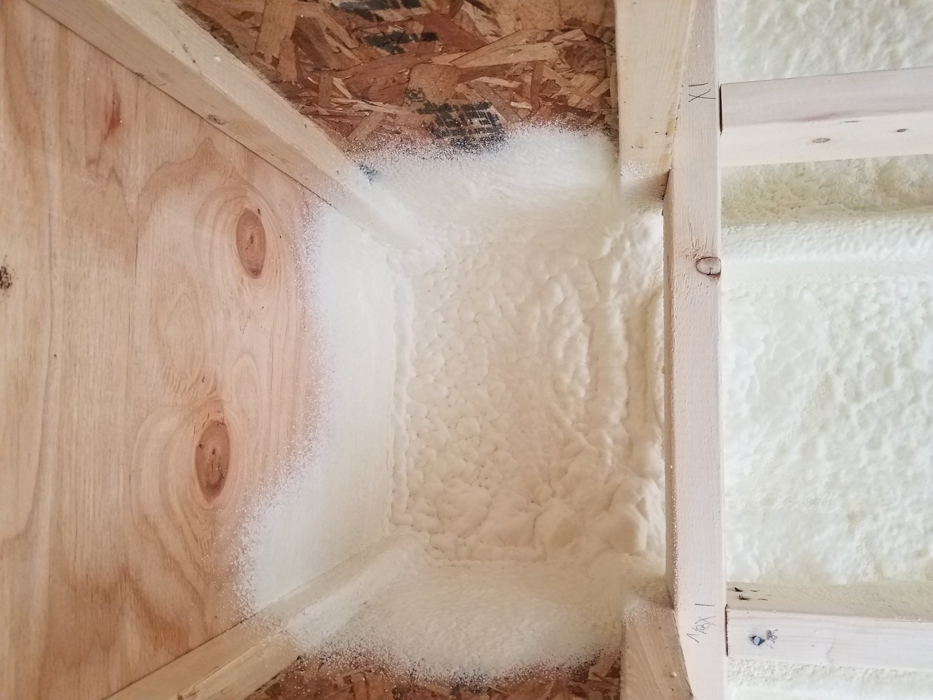 Spray foam filling a framed wall cavity over OSB sheathing