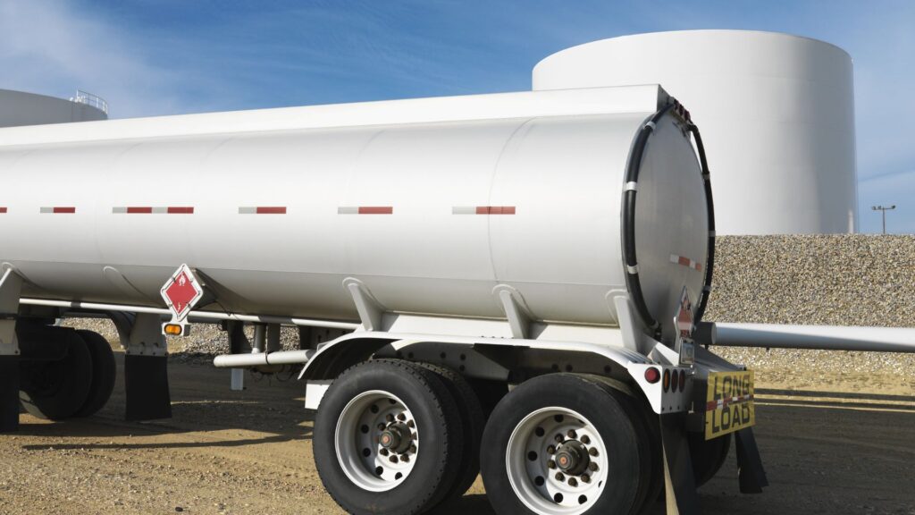 Fuel delivery tanker parked alongside bulk fuel storage tanks