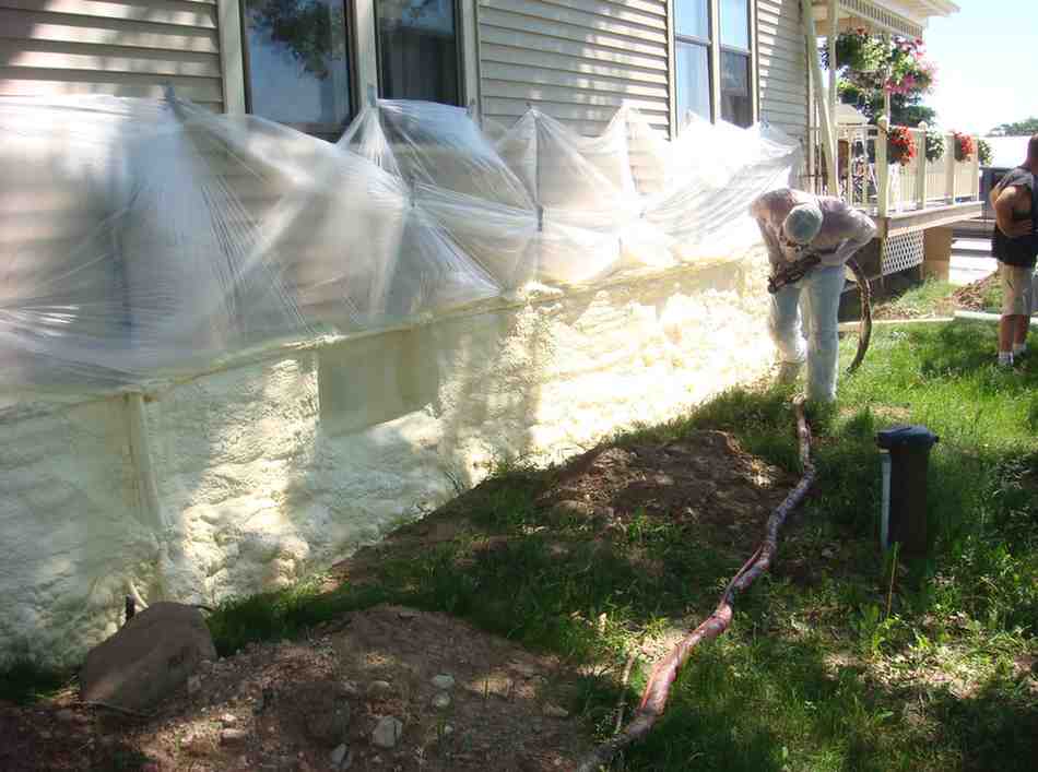 a man in a protective suit painting a house