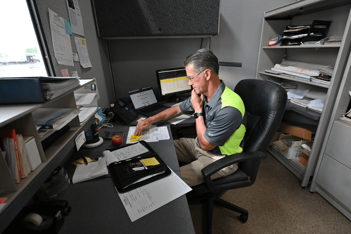 a man sitting at a desk with papers and a computer