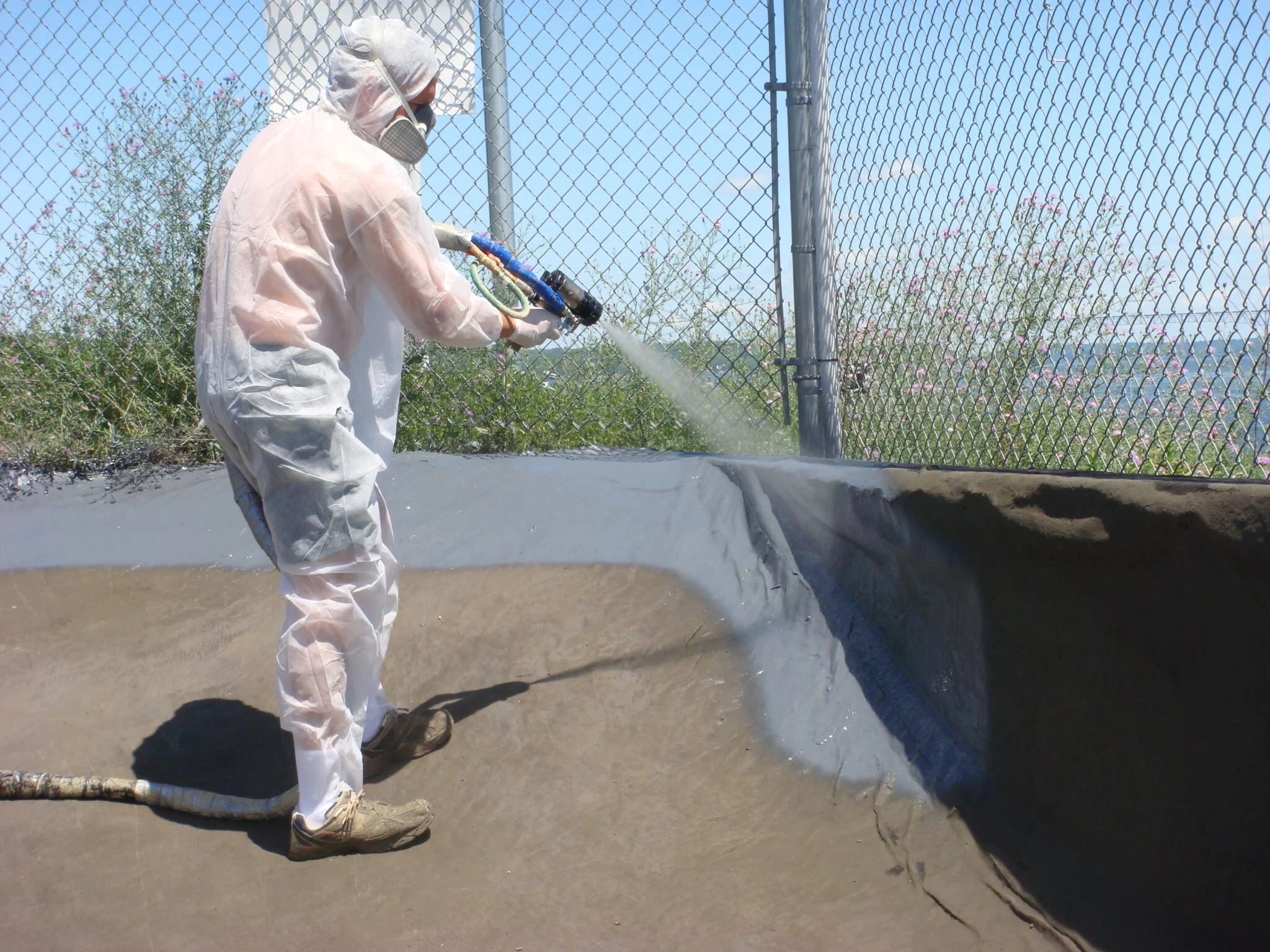 a person spraying water on a fence