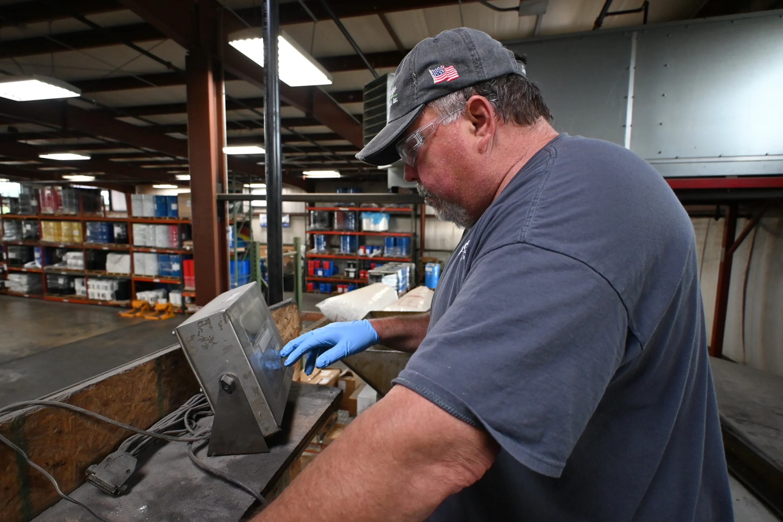 a man wearing a hat and gloves working on a machine