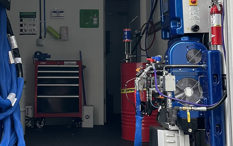 a blue machine with wheels and a hose