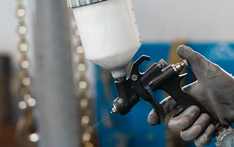 a person holding a spray gun