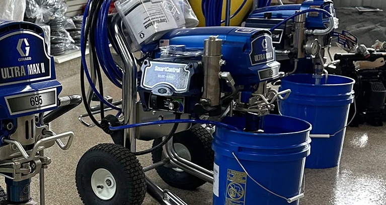 a blue machine with wheels and a hose