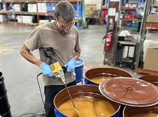 a man holding a drill in a factory