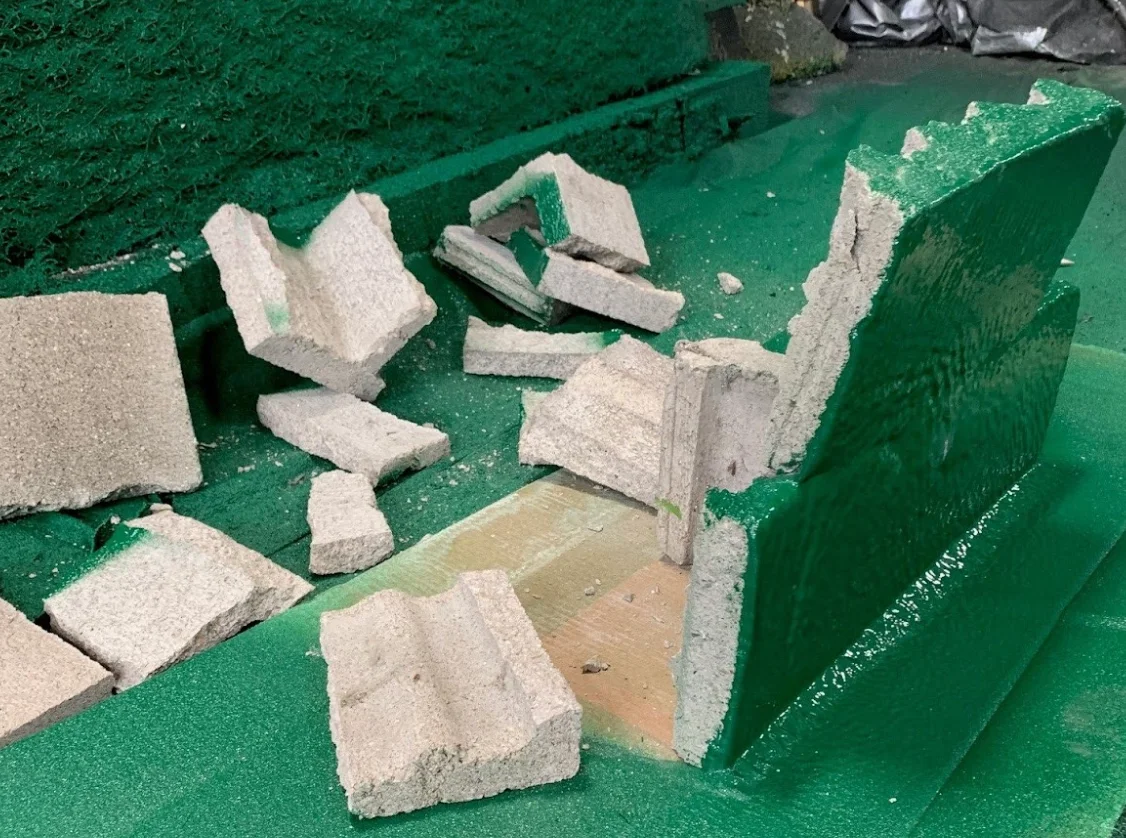 a broken concrete blocks on a green surface
