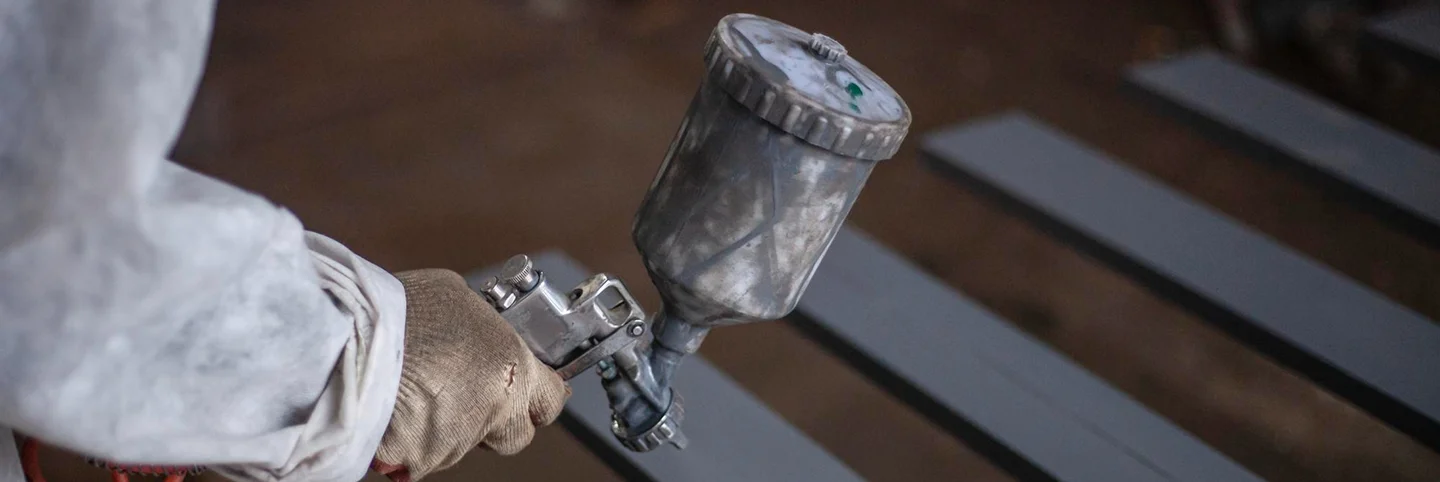a person holding a spray gun