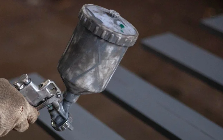 a person holding a spray gun