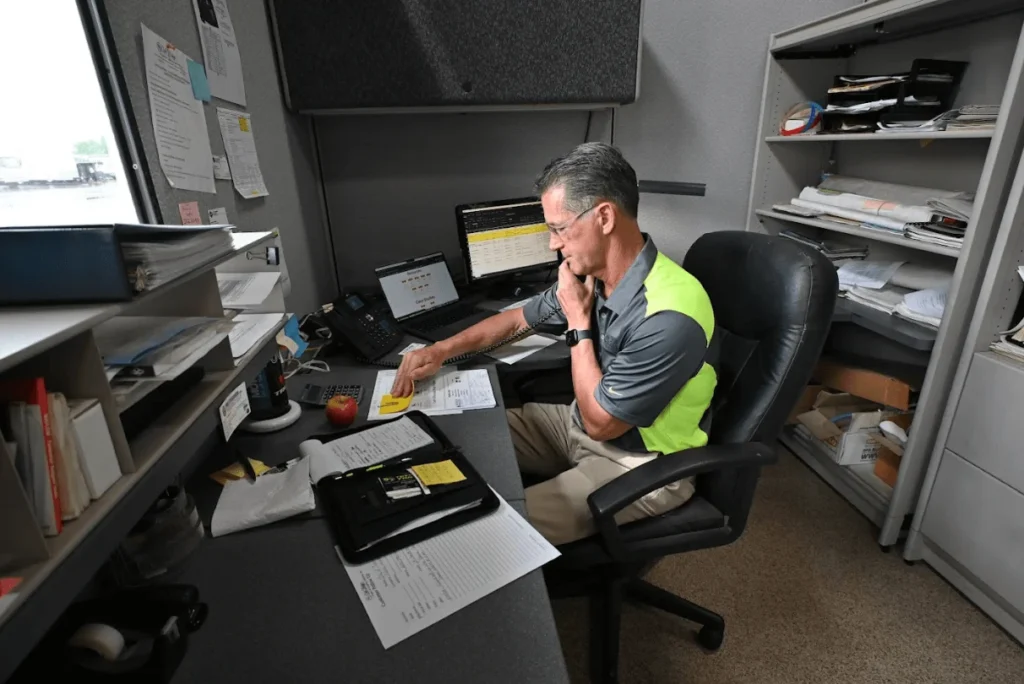 a man sitting at a desk with papers and a computer